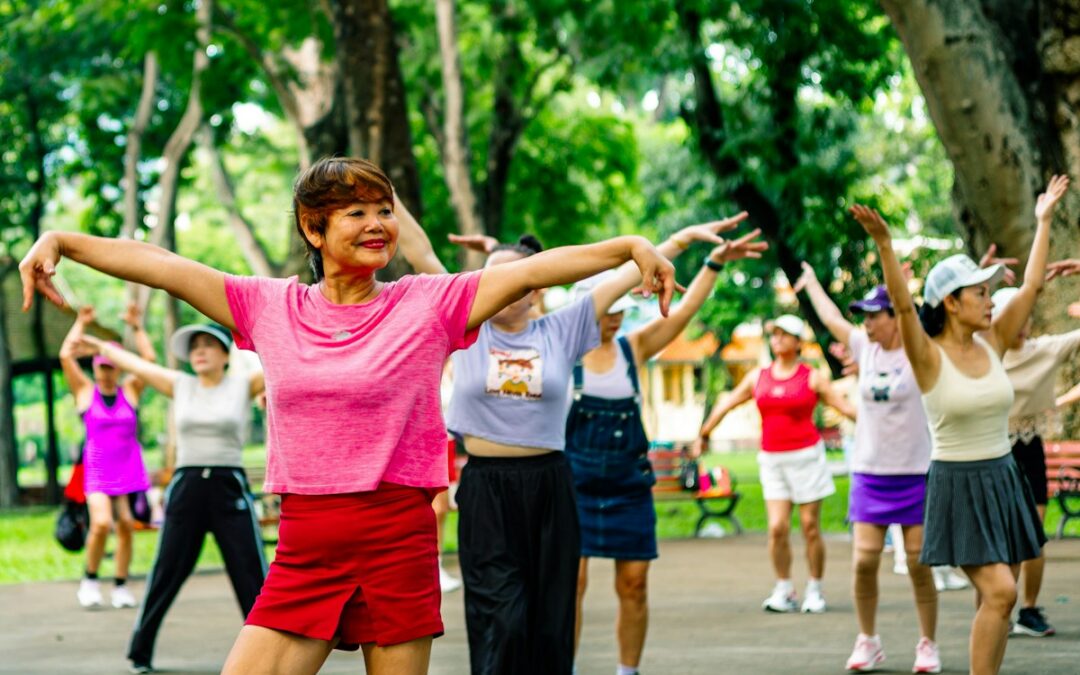 Women stretching their arms together in a green park