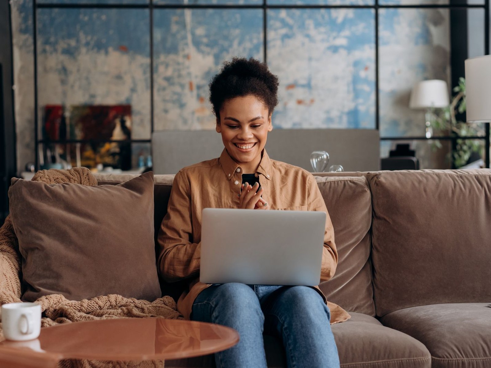 A patient joining a telehealth video visit from her sofa at home