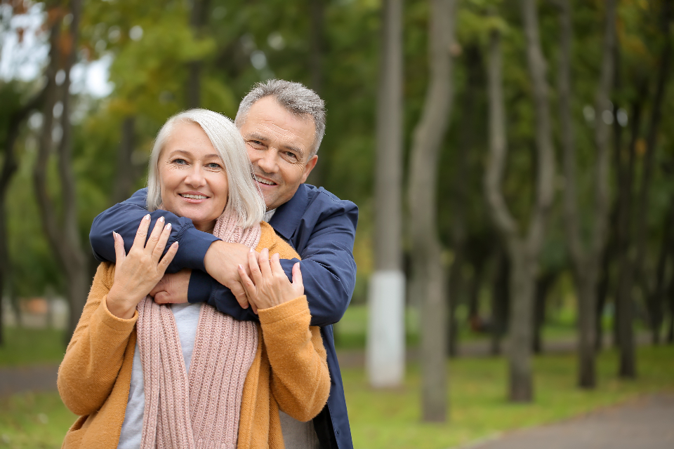 Happy mature couple embracing outdoors on an autumn walk