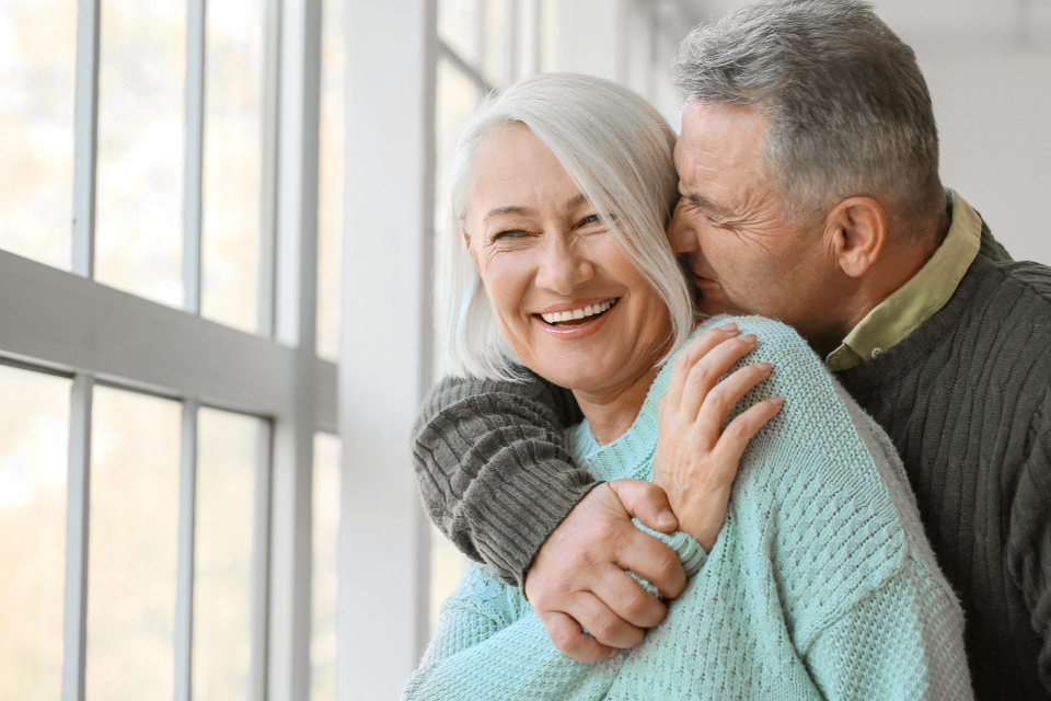 Smiling mature couple embracing in bright natural light
