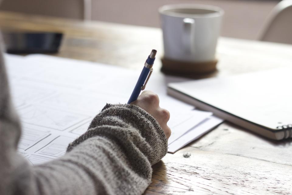 Person reviewing insurance paperwork at a desk with coffee